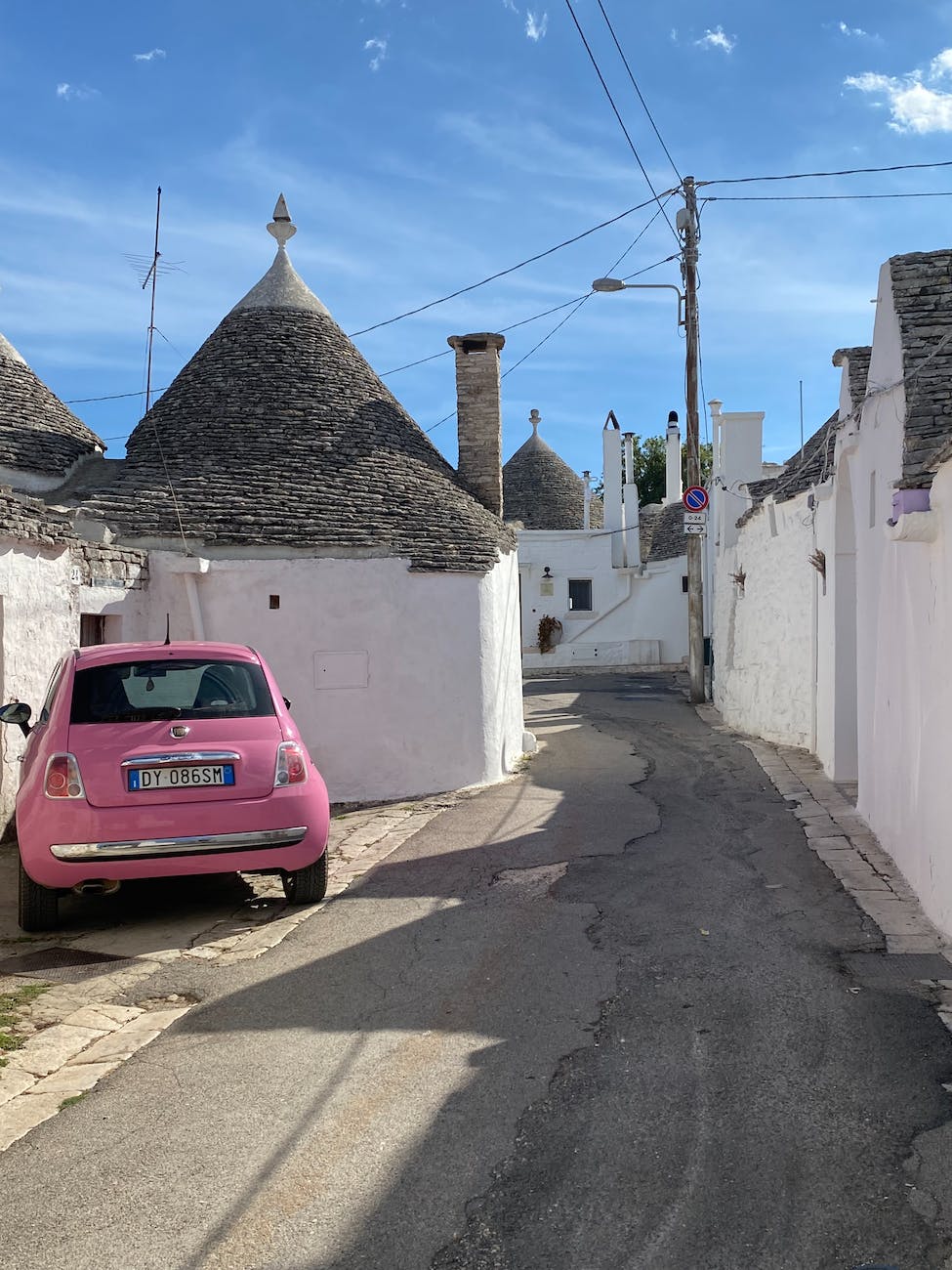 pink car parked beside white concrete building